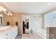 Neutral-toned bathroom features double sinks, white cabinets, tub and tile flooring at 420 Woodlark Ct, Indian Trail, NC 28079