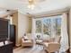 Cozy bedroom features two comfortable beige chairs and a large window overlooking trees at 420 Woodlark Ct, Indian Trail, NC 28079