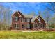 Stately two-story red brick home featuring classic architectural design and professionally landscaped front yard at 420 Woodlark Ct, Indian Trail, NC 28079
