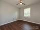 Cozy bedroom with wood floors, ceiling fan, and natural light from two windows at 445 Short Hills Dr, Charlotte, NC 28217