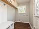 Functional laundry room with storage cabinets, a utility sink, and a window for natural light at 445 Short Hills Dr, Charlotte, NC 28217