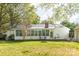 House exterior featuring a sunroom and large backyard with seating area at 5700 Carmel Station Ave, Charlotte, NC 28226