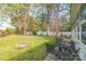 Spacious backyard featuring a fire pit, mature trees, and a white picket fence at 5700 Carmel Station Ave, Charlotte, NC 28226