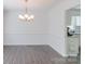 Dining room with hardwood floors, chandelier, and open doorway to kitchen at 5700 Carmel Station Ave, Charlotte, NC 28226