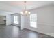 Bright dining room with chair rail detail, modern floors, updated lighting fixture, and large windows at 5700 Carmel Station Ave, Charlotte, NC 28226