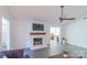 Cozy living room showcasing a white brick fireplace, ceiling fan, and updated floors at 5700 Carmel Station Ave, Charlotte, NC 28226