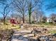 Landscaped backyard with stone pathway, mature trees, red shed, and scenic plantings at 601 Wilmar Nw St, Concord, NC 28025