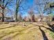 Spacious backyard featuring mature trees, stone walkway, and lush green lawn at 601 Wilmar Nw St, Concord, NC 28025
