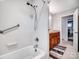 Bright bathroom showcasing a bathtub, shower, grab bar, and vanity with granite countertop and wood cabinets at 601 Wilmar Nw St, Concord, NC 28025