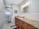 Well-lit bathroom with granite countertops, wood cabinets, subway tile backsplash, and a framed mirror at 601 Wilmar Nw St, Concord, NC 28025