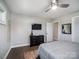Bright bedroom with dark hardwood floors, gray walls, ceiling fan, mounted TV and door leading to ensuite bathroom at 601 Wilmar Nw St, Concord, NC 28025