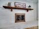 A stylish whitewashed brick fireplace with a rustic wood mantel adds warmth and charm to the living space at 601 Wilmar Nw St, Concord, NC 28025