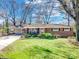 Charming brick home featuring a well-manicured lawn and inviting front porch with rocking chairs at 601 Wilmar Nw St, Concord, NC 28025