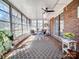 Bright and airy sunroom with tile flooring, exposed brick wall, ceiling fan, and an abundance of windows at 601 Wilmar Nw St, Concord, NC 28025