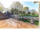 Deck overlooking an in-ground pool, lush green lawn, and mature trees, enclosed by a black fence at 7295 Three Sisters Ln, Concord, NC 28027