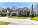 Stately brick home features a manicured lawn, circular drive, and elegant architectural details at 7295 Three Sisters Ln, Concord, NC 28027