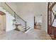 Grand foyer with tile floors, staircase with iron railing, and view into the home office at 7295 Three Sisters Ln, Concord, NC 28027