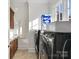 Bright laundry room featuring side-by-side washer and dryer, cabinets, and window at 7295 Three Sisters Ln, Concord, NC 28027