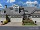 Beautiful two-story home featuring a three-car garage and well-maintained landscaping under a blue sky at 8015 Greenview Terrace Ct, Charlotte, NC 28277