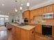 Spacious kitchen flows into the living area, featuring stainless steel appliances and an island at 8015 Greenview Terrace Ct, Charlotte, NC 28277