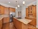 Well-equipped kitchen has granite countertops, wooden cabinets, stainless appliances, and a gas cooktop island at 8015 Greenview Terrace Ct, Charlotte, NC 28277