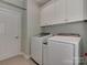 This laundry room is equipped with a washer, dryer, and ample overhead storage cabinets at 8015 Greenview Terrace Ct, Charlotte, NC 28277
