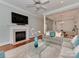 Cozy living room with a fireplace, TV, and an open layout leading into the dining area at 8015 Greenview Terrace Ct, Charlotte, NC 28277