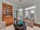 Bright living room boasts natural light with a custom bookshelf, chair and access to a side porch at 8015 Greenview Terrace Ct, Charlotte, NC 28277