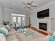 Bright living room with a fireplace, TV, and French doors, offering a cozy and stylish space at 8015 Greenview Terrace Ct, Charlotte, NC 28277