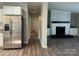 Open-concept kitchen and living area with stainless steel appliances and a cozy fireplace at 8502 Simpson Rd, Waxhaw, NC 28173
