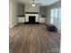 Open-concept living room with stone fireplace, built-in shelves, and modern flooring at 8502 Simpson Rd, Waxhaw, NC 28173