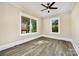 Cozy bedroom with neutral walls, two windows, and stylish grey wood-look flooring at 1132 E Main St, Albemarle, NC 28001