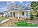 Charming bungalow features a covered porch, painted brick, black door, and a well-maintained front yard at 1132 E Main St, Albemarle, NC 28001