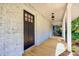 Inviting front porch featuring wooden floors, brick walls, a hanging lantern, and ample space at 1132 E Main St, Albemarle, NC 28001