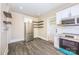 Well-lit kitchen with stainless steel appliances, floating shelves, and gray wood-look flooring at 1132 E Main St, Albemarle, NC 28001