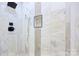 Close-up of shower featuring marble-patterned walls, a niche, and a rainfall shower head at 1132 E Main St, Albemarle, NC 28001