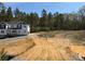 New two-story home featuring white siding, gray accents, and a wooded backdrop, in early stage of construction at 1259 Willow Grove Ln # 100, York, SC 29745