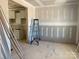 Living room with drywall in progress, featuring an open layout with the kitchen, with a ladder in the center at 1259 Willow Grove Ln # 100, York, SC 29745