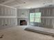 Large living room with drywall nearing completion, featuring a window, fireplace, and electrical outlets at 1259 Willow Grove Ln # 100, York, SC 29745