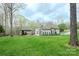 Expansive backyard features a covered outdoor living area, a large lawn, and mature trees at 2017 Colorado Ct, Lancaster, SC 29720