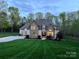Charming home with a combination of stone and siding, lush green lawn, and inviting curb appeal set at twilight at 2017 Colorado Ct, Lancaster, SC 29720