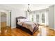 Primary bedroom featuring hardwood floors, a decorative light fixture, and large windows allowing natural light at 2017 Colorado Ct, Lancaster, SC 29720