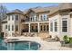 Back of house shows a beautiful pool, spa, patio, and seating area for relaxation and entertaining at 2017 Colorado Ct, Lancaster, SC 29720
