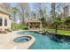 Beautiful pool and spa surrounded by lush greenery, with a covered patio for outdoor relaxation at 2017 Colorado Ct, Lancaster, SC 29720