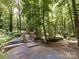 Wooden bridge along a walking trail surrounded by lush green trees and foliage at 4148 Cedar Point Ave, Matthews, NC 28104