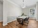 Dining room featuring modern chandelier, wainscoting and a dining table with seating for six at 4148 Cedar Point Ave, Matthews, NC 28104