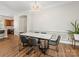 Dining room featuring a statement chandelier, wainscoting and a dining table with seating at 4148 Cedar Point Ave, Matthews, NC 28104