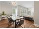 Open-concept dining area flowing into a living room featuring a statement chandelier and abundant natural light at 4148 Cedar Point Ave, Matthews, NC 28104
