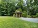 Wooden gazebo on a lush green lawn next to a walking path and pond at 4148 Cedar Point Ave, Matthews, NC 28104