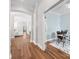 Hallway with hardwood floors leading to an office space and living area with a fireplace at 4148 Cedar Point Ave, Matthews, NC 28104